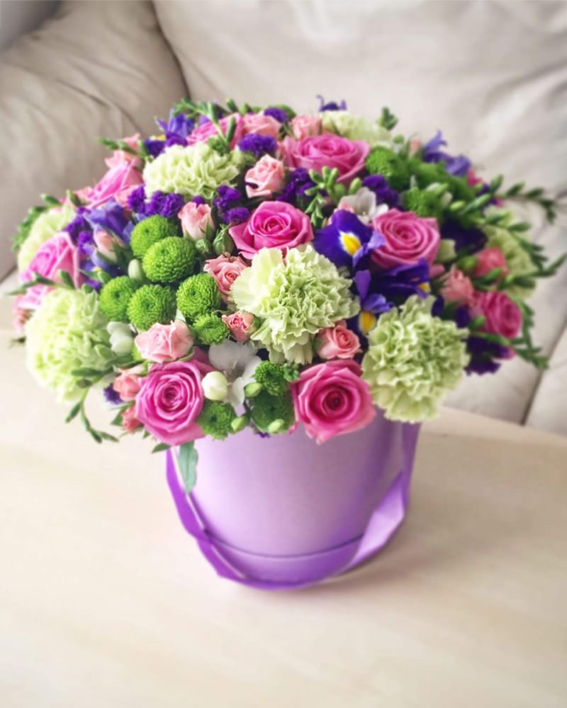 Ziedu kaste ar zaļām neļķēm, rozēm