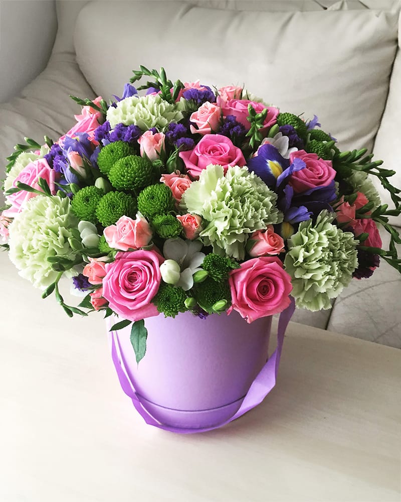 Ziedu kaste ar zaļām neļķēm, rozēm